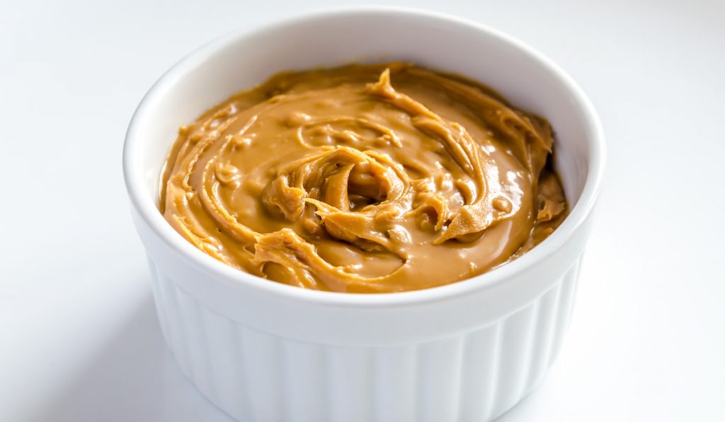 Peanut Butter in a bowl on white background 