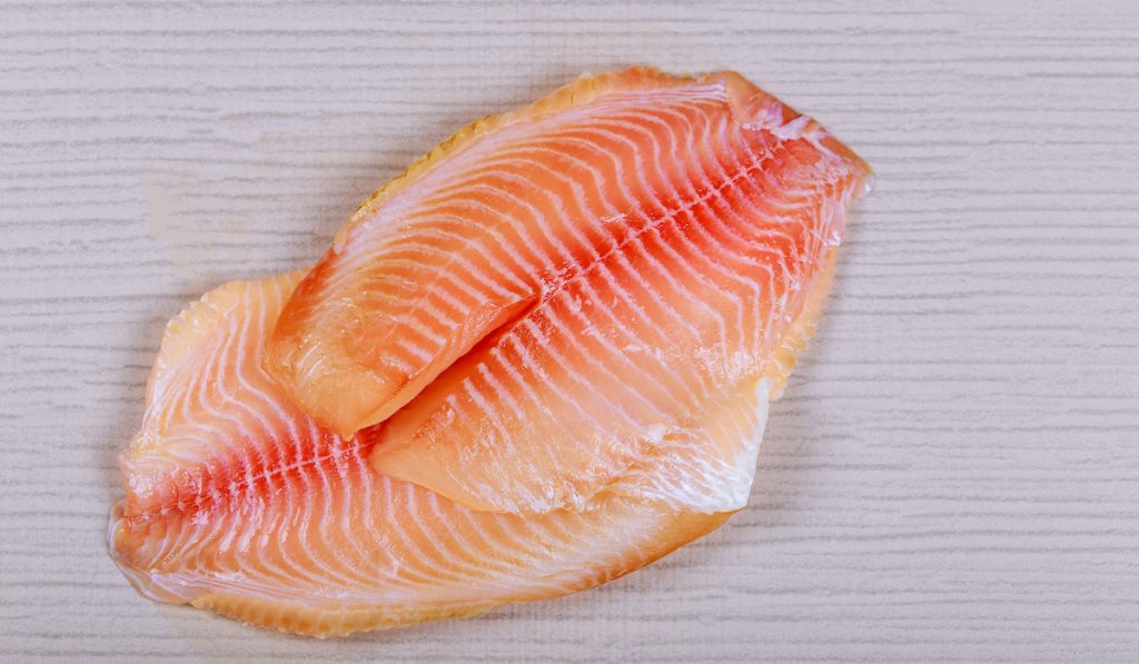 Raw fresh fish fillet tilapia on wooden table
