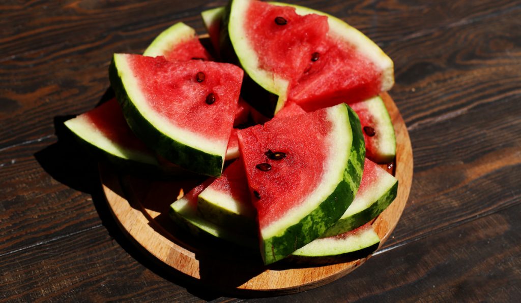 Ripe slices of watermelon on wooden plate 