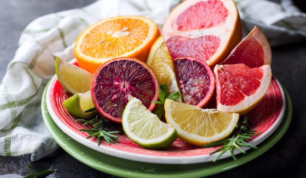 Sliced citrus fruit on the plate and cloth on black table 