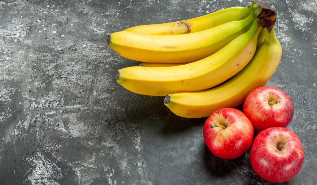 bananas and apples on dark gray background