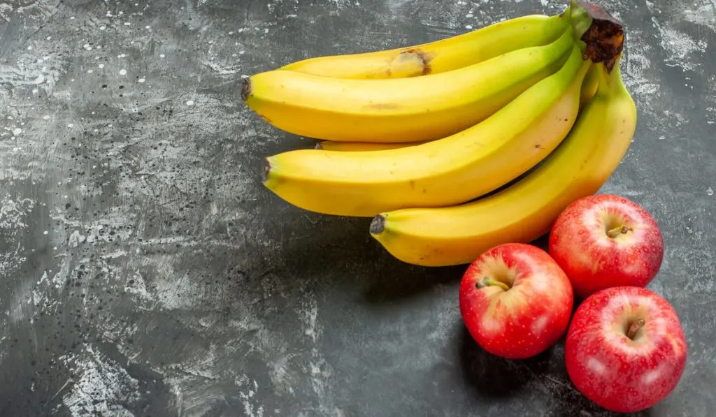 bananas and apples on dark gray background