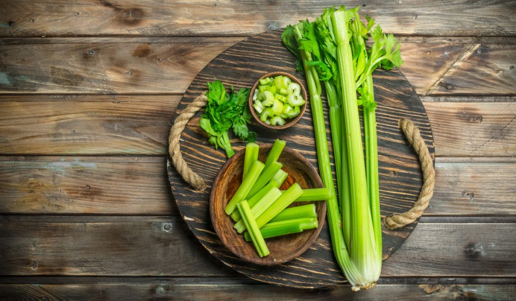 fresh celery on a wooden tray